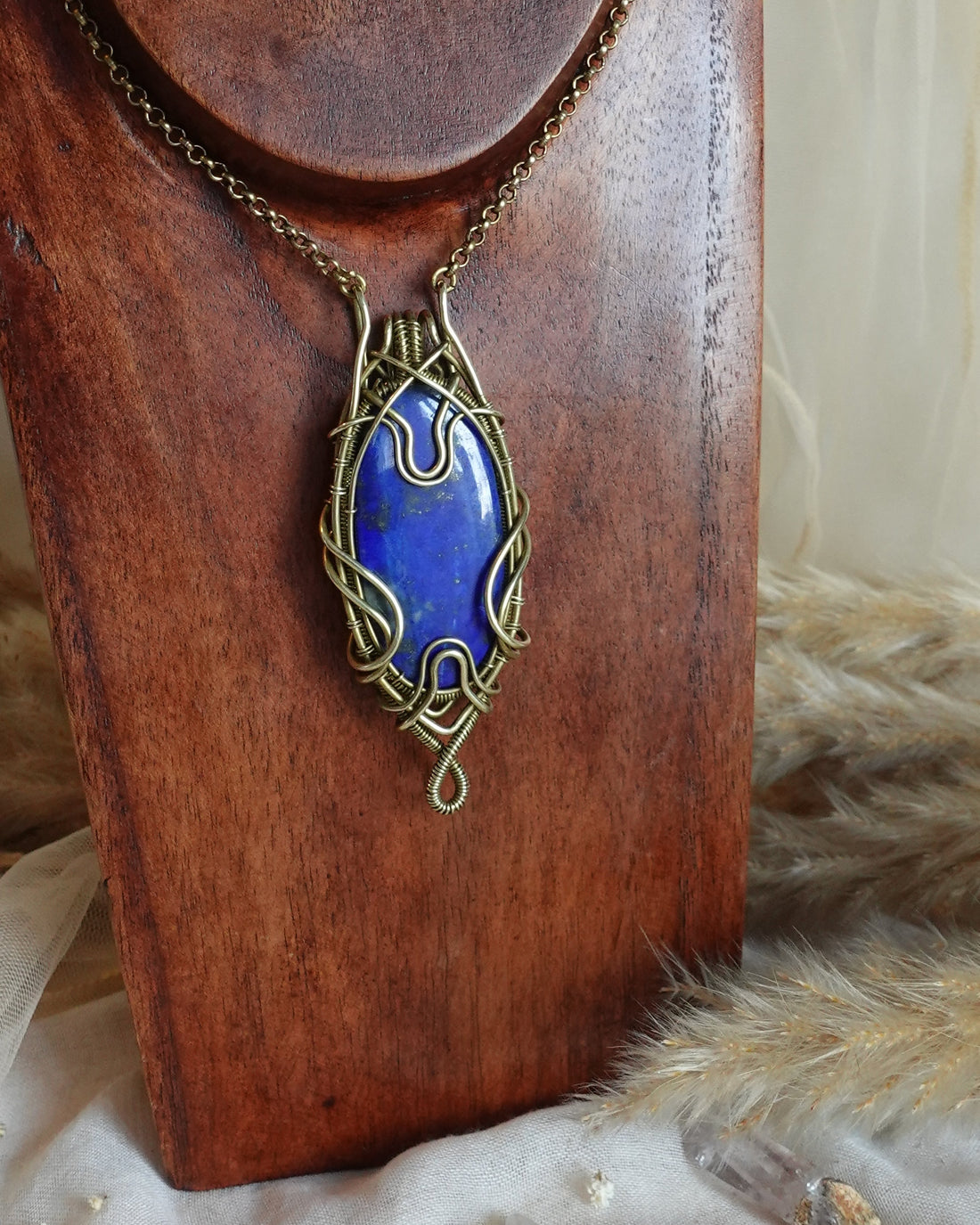 Lapis lazuli wirewrap pendant showing deep blue stone with golden pyrite, the stone of voice and feminine wisdom