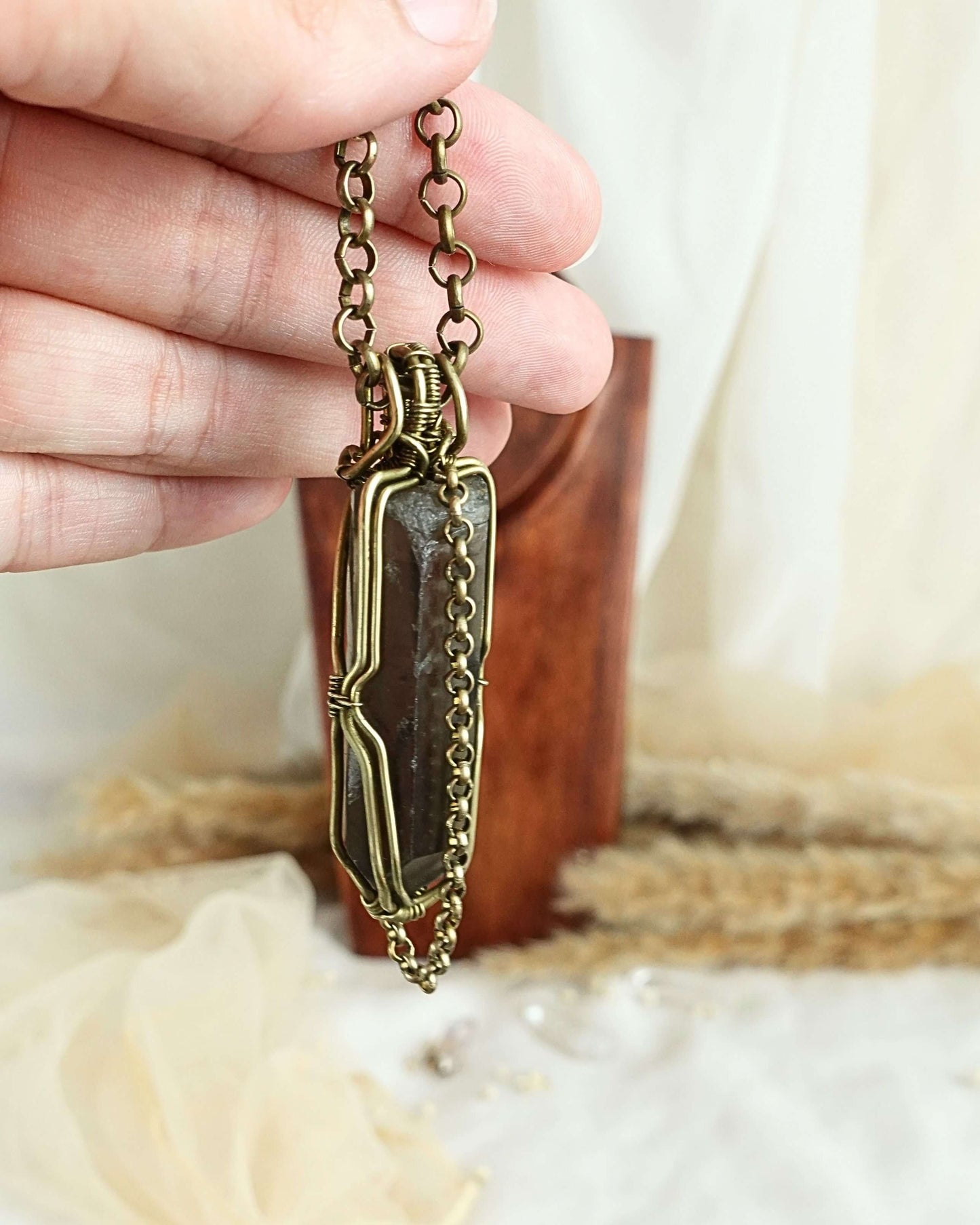 Detail of brass wirework holding the black quartz pendulum