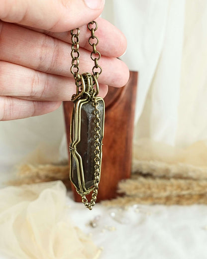 Detail of brass wirework holding the black quartz pendulum