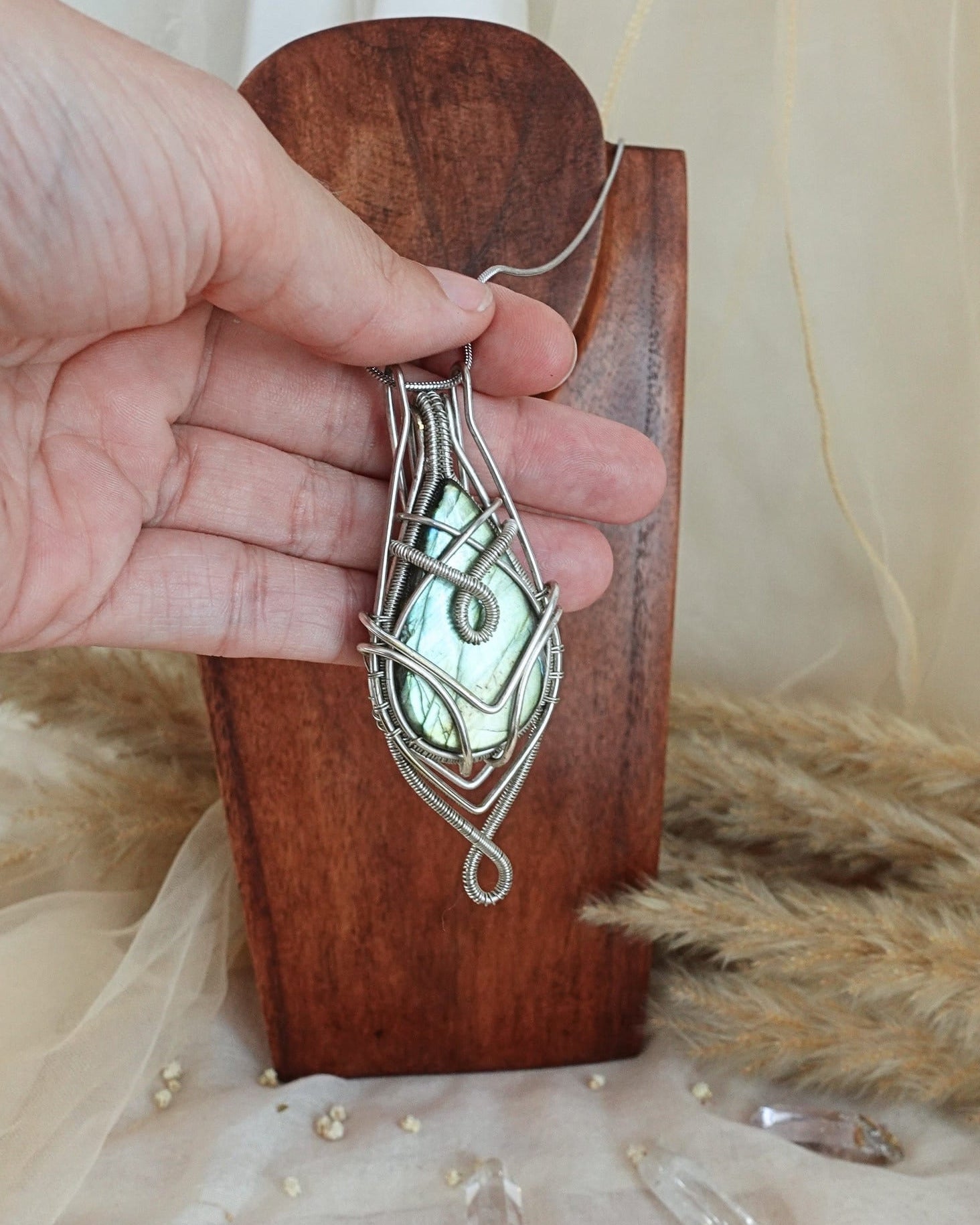Side view of silver-plated labradorite wirewrap pendant on chain