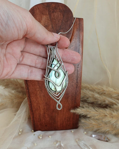 Side view of silver-plated labradorite wirewrap pendant on chain