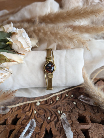 Side view of mahogany obsidian bracelet in adjustable brass wire