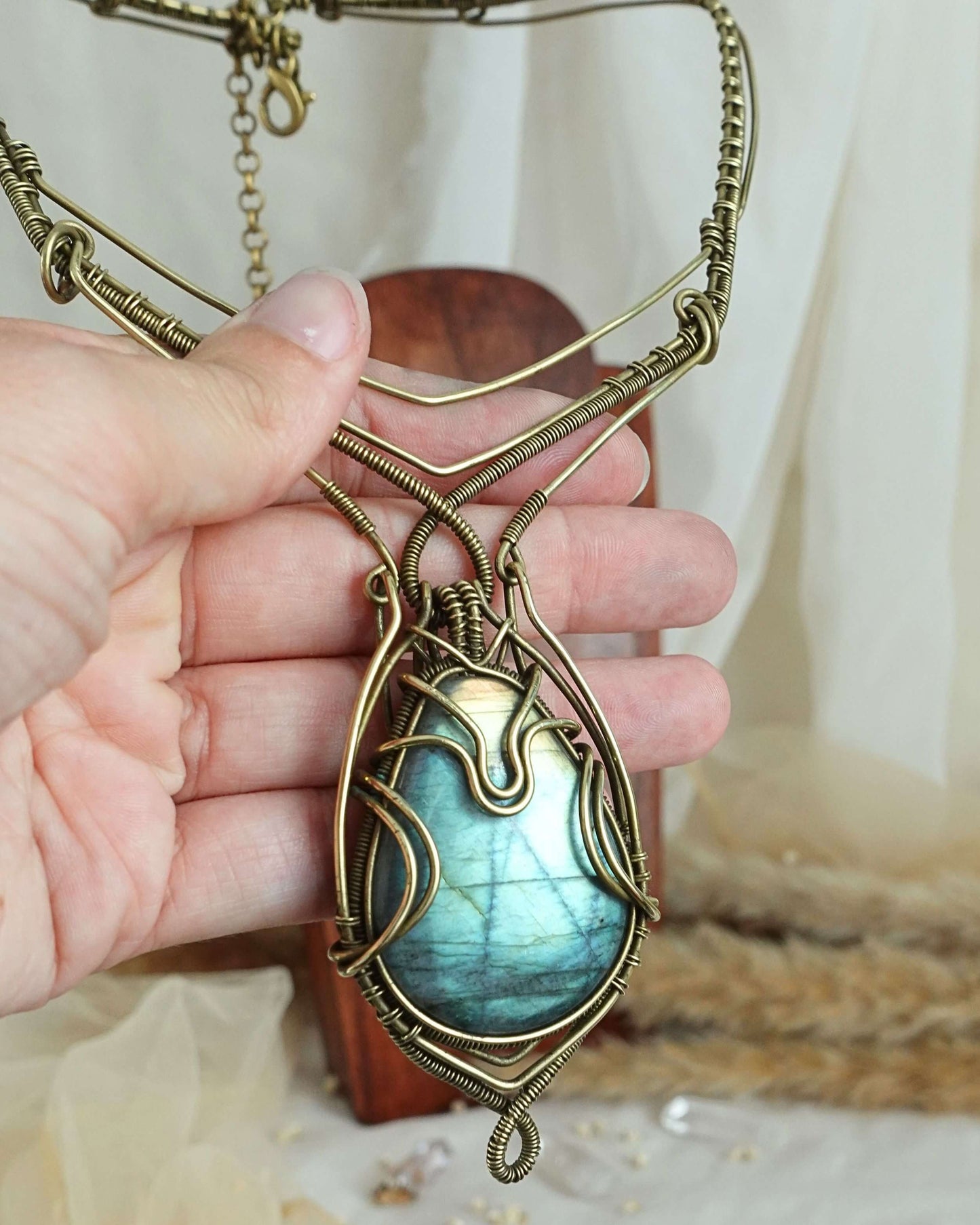 Side view of handmade labradorite wirewrap pendant on brass chain