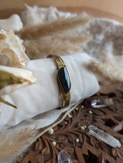Detail of brass wirework holding the rainbow obsidian stone