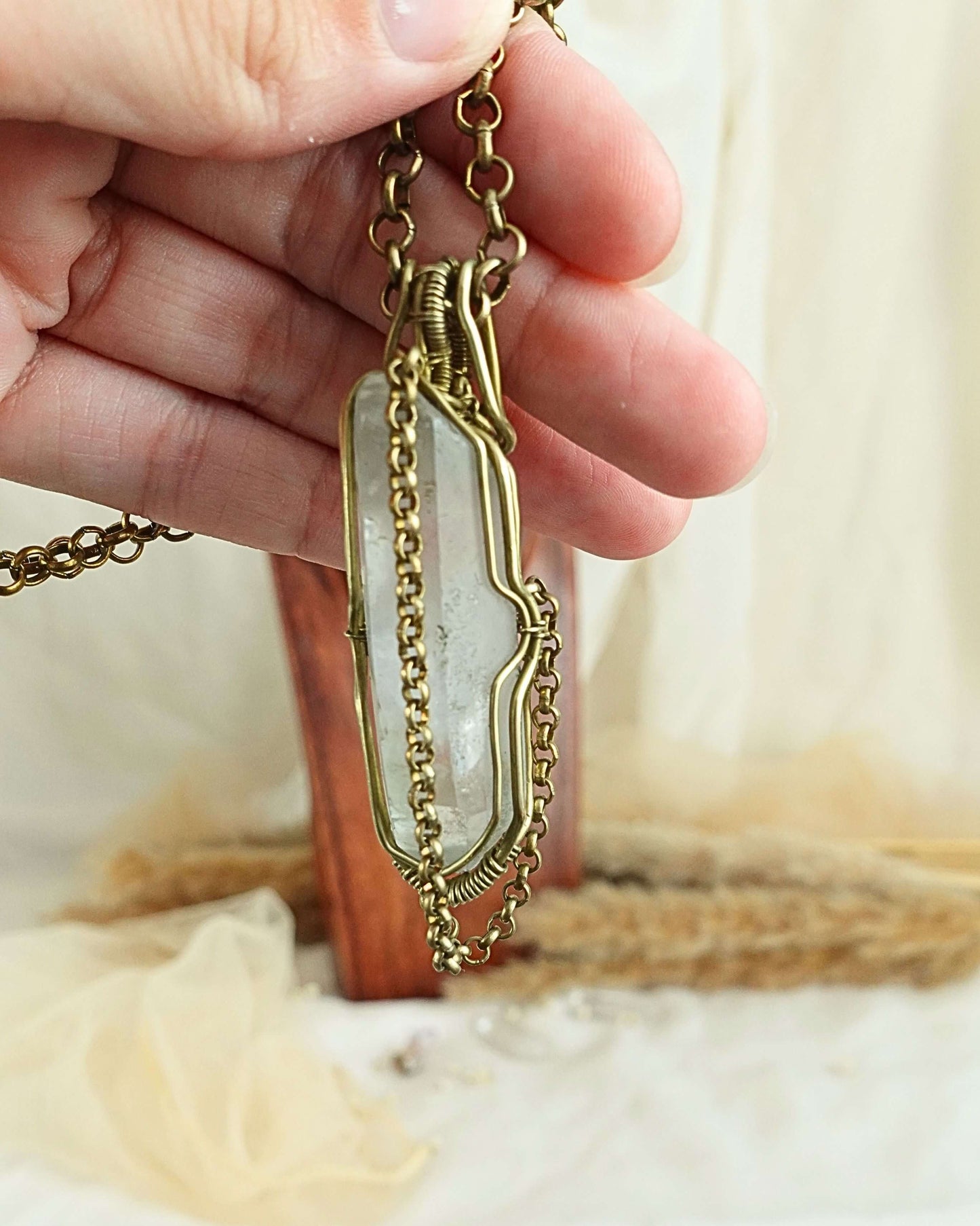 Detail of brass wirework holding the clear quartz pendulum