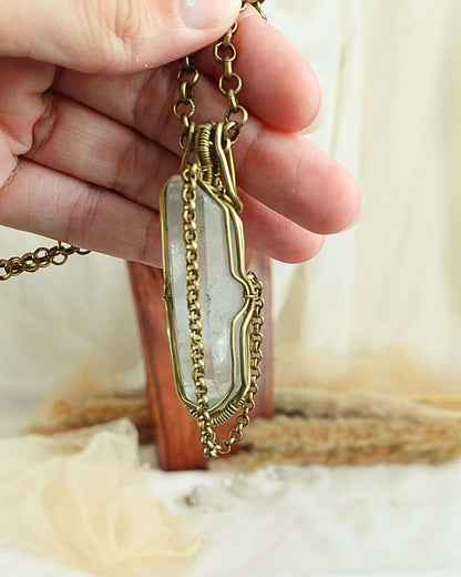 Detail of brass wirework holding the clear quartz pendulum